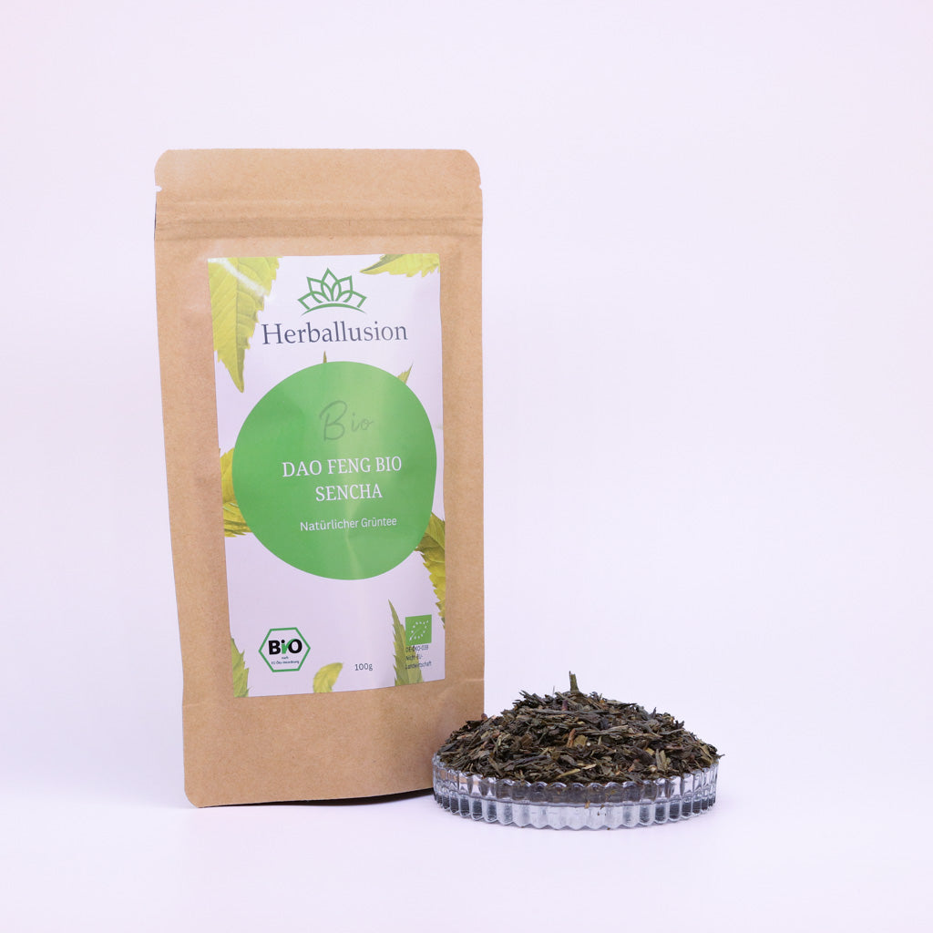 100g-Beutel Bio-Grüntee ‚Dao Feng Bio Sencha‘ mit gelb-grünem Etikett, daneben Glasschale mit losem Tee.