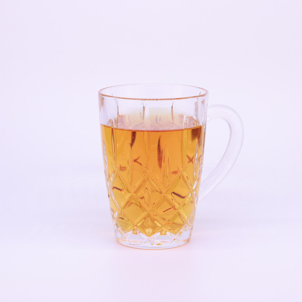 Nachtmann Teetasse Noblesse gefüllt mit honigfarbenem Tee auf weißem Hintergrund