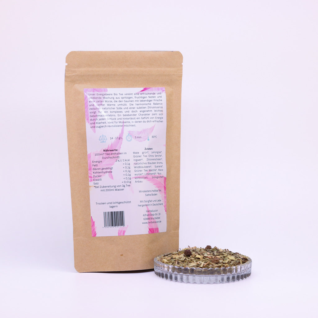 100g-Beutel Bio-Matetee ‚Energiebeere‘ mit rosa-blauem Etikett Rückseite, daneben Glasschale mit losem Tee.