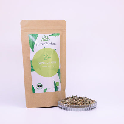 100g-Beutel Bio-Matetee ‚Green Vitality‘ mit gelb-grünem Etikett, daneben Glasschale mit losem Tee.

