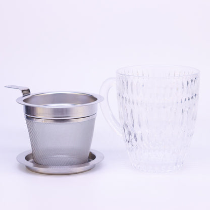 Nachtmann Teetasse Ethno steht auf weißem Hintergrund. Daneben steht das passende Teesieb