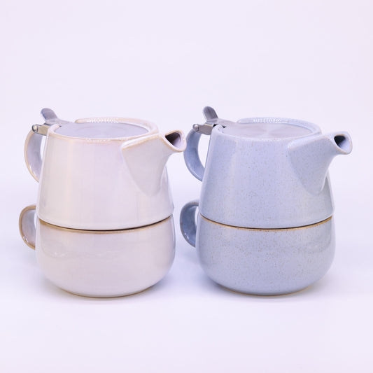 Tea-for-one Set in blau und creme farben stehen nebeneinander auf weißem Hintergrund.