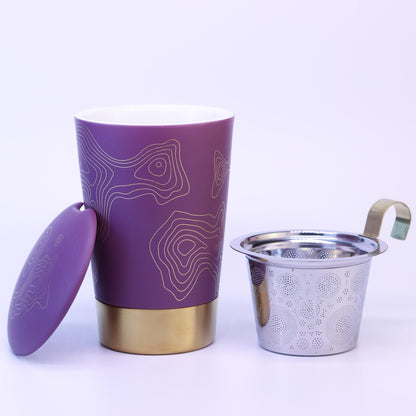 Teaeve Precious in lila steht auseinander gebaut auf weißem Hintergrund. Daneben steht das Teesieb und der Deckel der Tasse