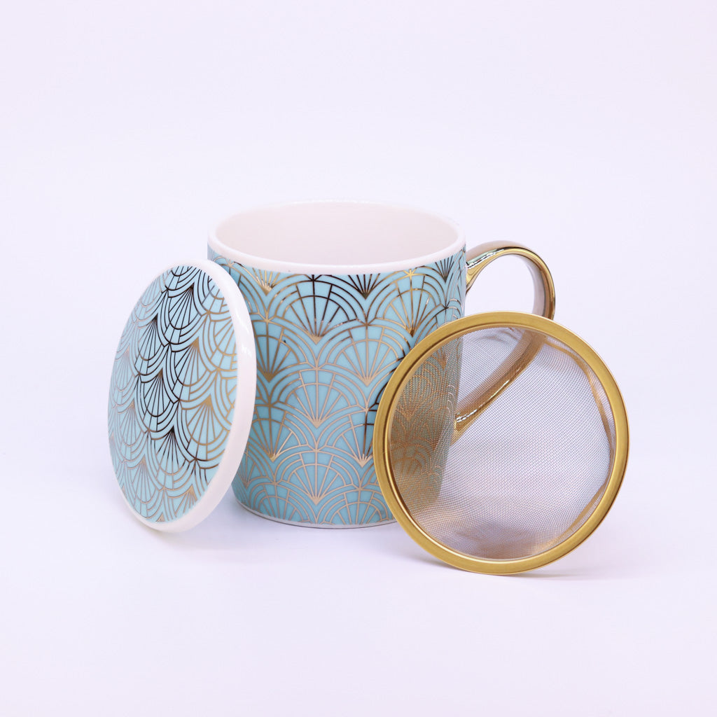 Türkise Teetasse mit goldener Verzierung im Art Déco Stil, 400 ml Fassungsvermögen, auf weißem Hintergrund. Neben der Tasse liegt das goldene Teesieb.