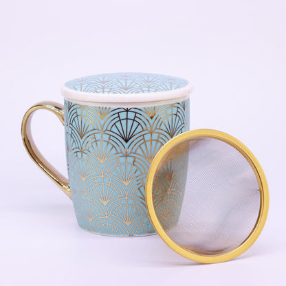 Türkise Teetasse mit goldener Verzierung im Art Déco Stil, 400 ml Fassungsvermögen, auf weißem Hintergrund. Neben der Tasse liegt das goldene Teesieb.